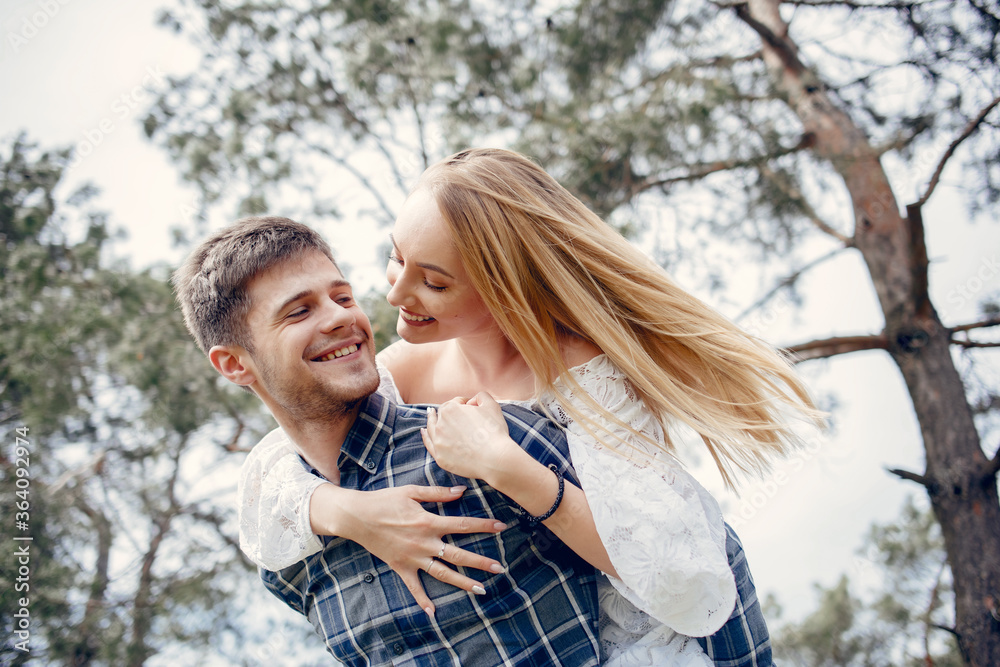 Obraz premium Cute couple in a park. Lady in a white dress. Guy in a blue shirt