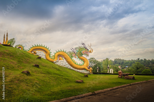 Yellow dragon head at Wat Huay Pla Kang, bublic Chinese temple in Chiang Rai Province, Thailand with dramatic blue sky background. photo