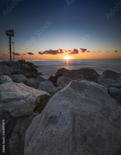 Lighthouse in Riccione port on the Adriatic sea at sunrise in summer