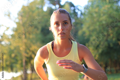 Fototapeta Naklejka Na Ścianę i Meble -  Young woman in sports clothing running while exercising outdoors.