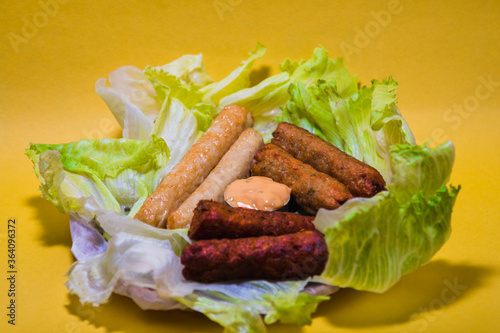 Seek kebabs with sausages on greens