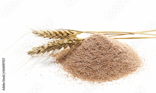 Dry spelt bran pile with ears of wheat isolated on white background