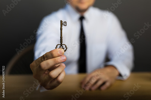 Key to success in businessman hand on background of the sky.