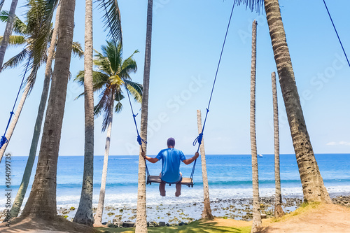 Tourist swinging on a swing overlooking the Indian Ocean © dvad