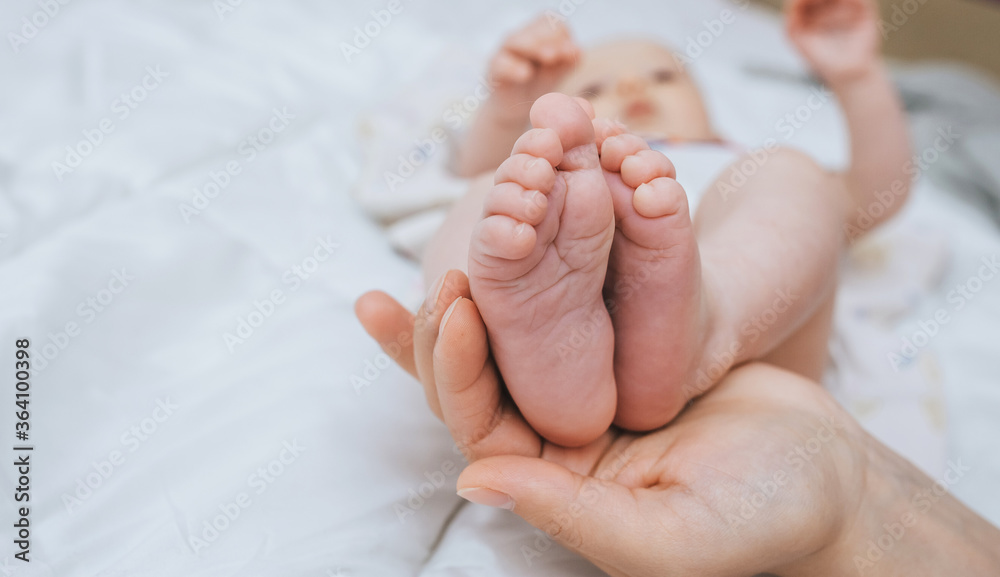 Loving mother holds the legs of a small child in the palm of his hand close-up. Woman's happiness. Photography, concept. Loving mother holds the legs of a small child in the palm of his hand close-up. Woman's happiness. Photography, concept.