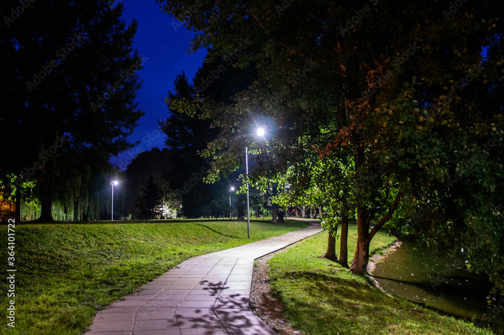 Night summer European park with river and promenade Night summer European park with river and promenade