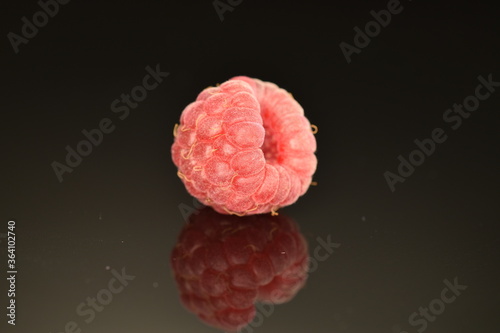 Juicy red raspberries, close-up, isolated on black.
