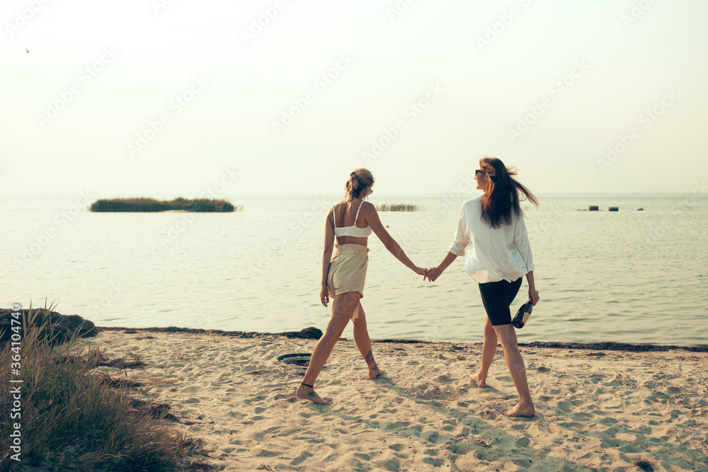 lesbian couple have fun on beach Beautiful women friends happy relax near sea when sunset in evening Lifestyle lesbian couple travel on beach concept.