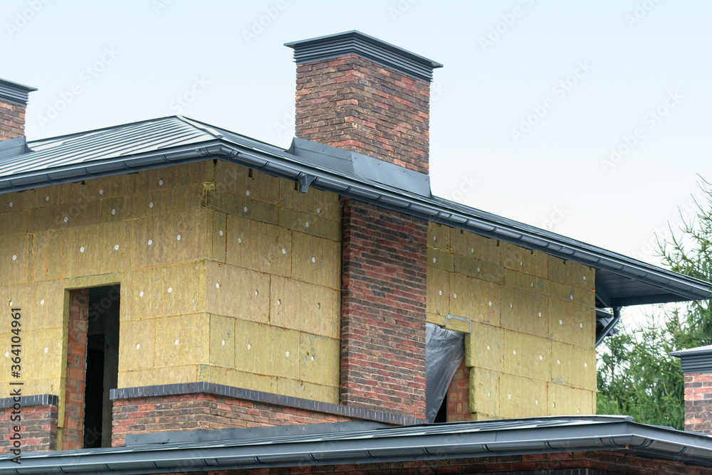 Insulation of brickwork with mineral wool. Thermal insulation of a house wall on a building site Insulation of brickwork with mineral wool. Thermal insulation of a house wall on a building site