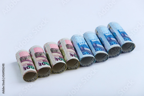 Doha, Qatar - May 03, 2020: Currencies and money exchange trading concepts. Qatari 500 ,100,50,10,5,1 Riyals Bank Note .& Coins ,Qatari Currency roll . photo