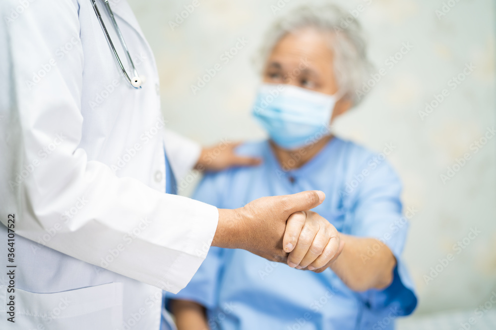 Doctor with stethoscope to checking Asian senior or elderly old lady woman patient wearing a face mask in hospital for protect infection and kill Novel Coronavirus Covid-19 virus.