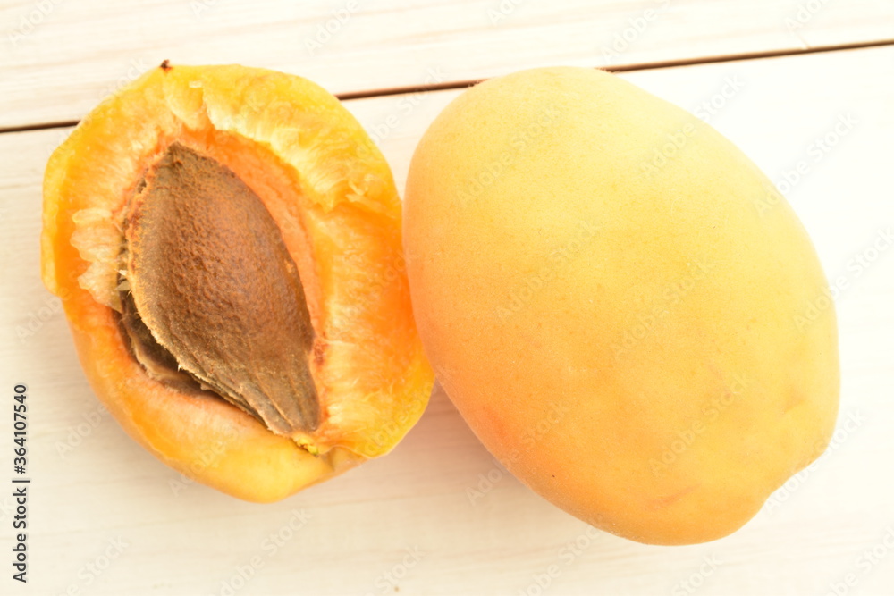 Juicy organic apricots, close-up, on a white wooden table. Juicy organic apricots, close-up, on a white wooden table.