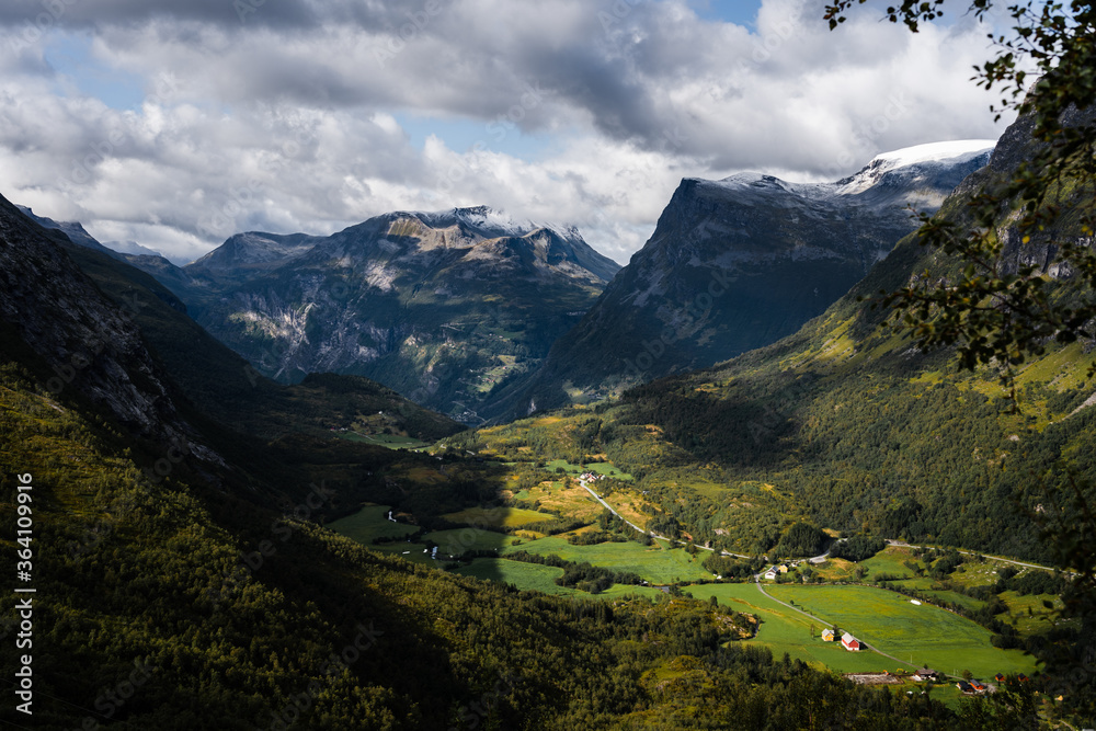 Naklejka premium Norwegian valley surrounded by mountains on a summer day