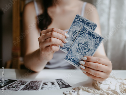 woman holding in her hands tarot cards