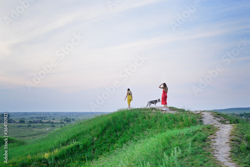 Two young girls with husky dog on the mountains
