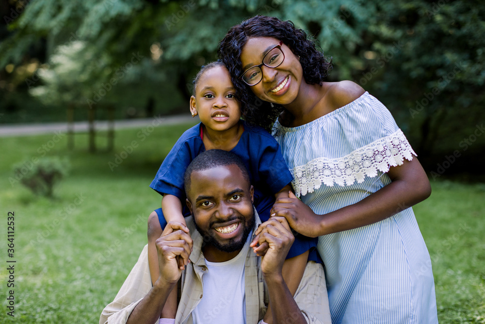 Family outdoor recreation, happy family in love concept. Joyful attractive african family playing in the park. Mother, father and little daughter having picnic at summer park Family outdoor recreation, happy family in love concept. Joyful attractive african family playing in the park. Mother, father and little daughter having picnic at summer park
