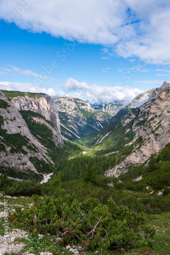 Looking across a deep V-shaped, forested valley towards the spectacular Tre Cime in the Dolomites of Northern Italy