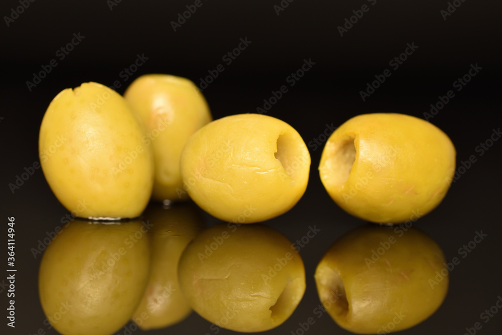 Green pitted olives, close-up, on a black background. Green pitted olives, close-up, on a black background.