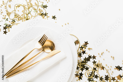 Golden table setting with shiny stars and beads on white. Space for text.