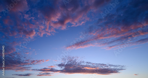 beautiful panoramic photo of the blue sky and clouds painted pink by the sunset