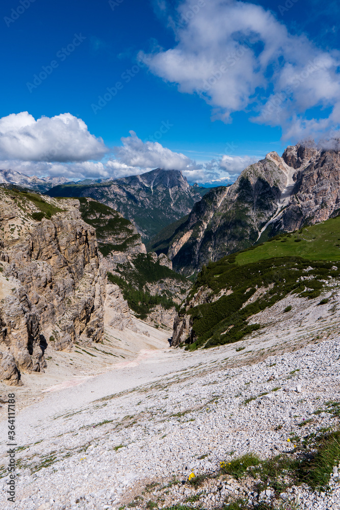Looking across a deep V-shaped, forested valley towards the spectacular Tre Cime in the Dolomites of Northern Italy
