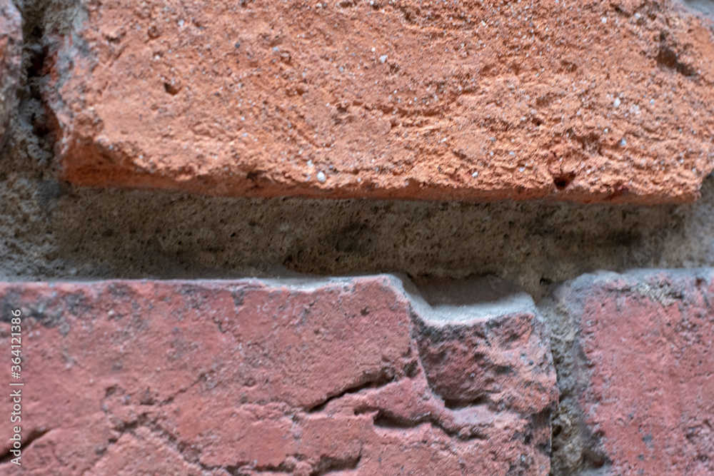 Old broken red brick wall in close-up