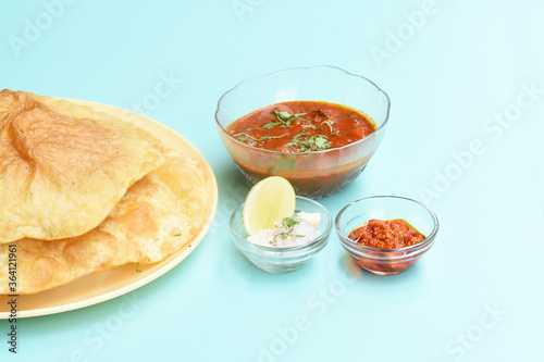 Indian dish spicy Chick Peas curry also known as Chole Bhatura and Chana Masala or Chole or Chickpeas Masala curry,traditional north indian lunch served with fried puri or flatbreads,selective focus