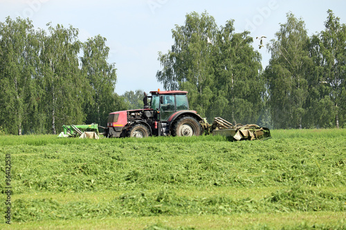 tractor mows green grass