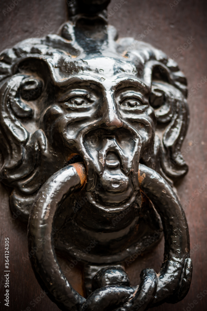 Antique metal door knocker with face