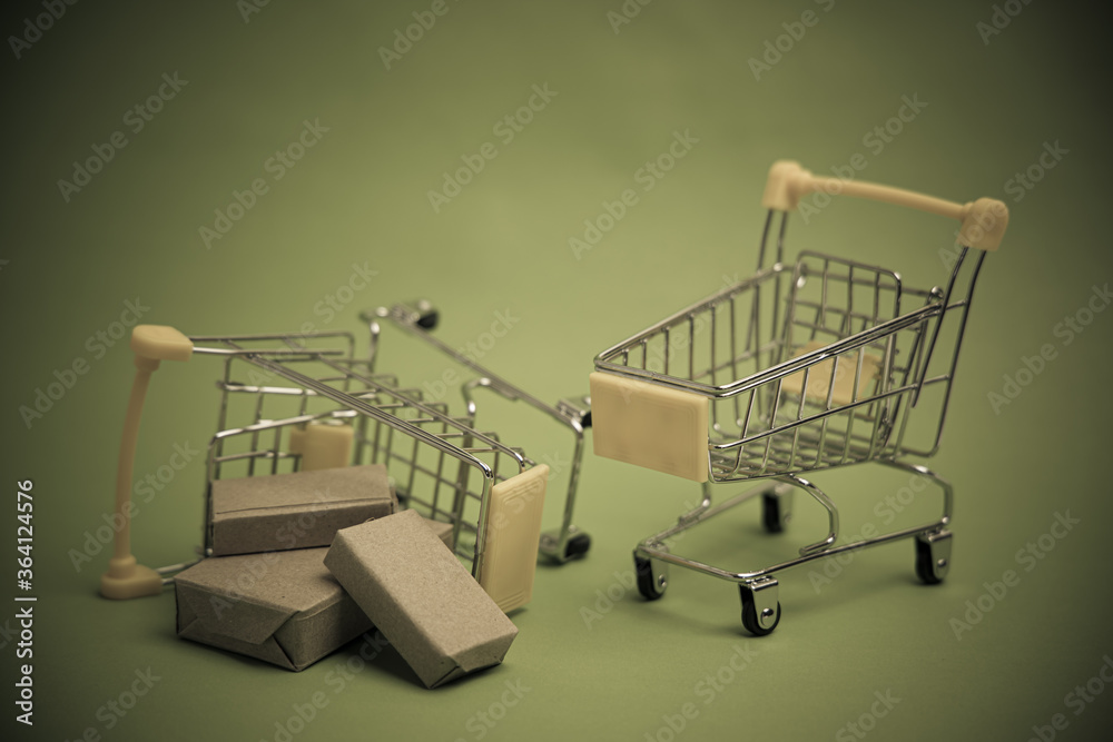 Yellow shopping cart or trolley and small , Product box, Package box , Isolated on On a black background is not bright .And business ideas failed, bankrupt.