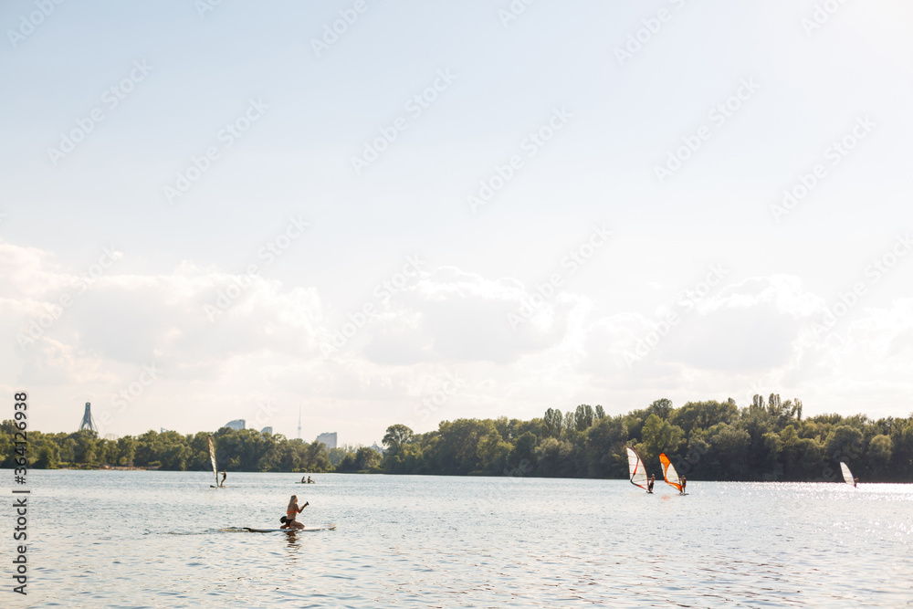 Young attractive woman on stand up paddle board in the lake, SUP