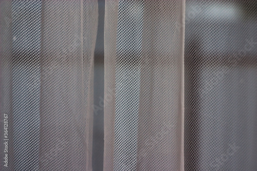 transparent tulle curtain on the window (fragment)