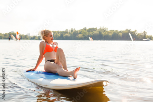 Young attractive woman on stand up paddle board in the lake, SUP © Angelov