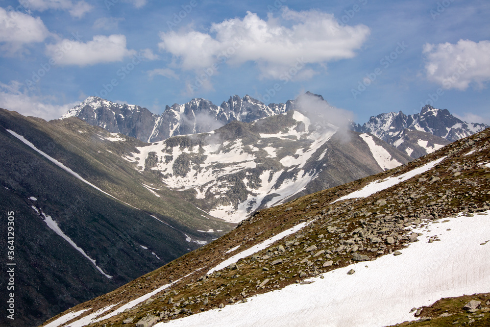 Snowy mountains that begin to melt and become green with spring and around