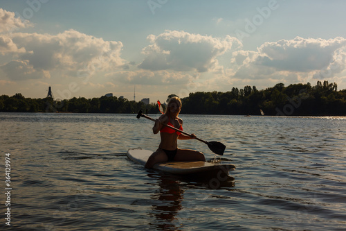 Young attractive woman on stand up paddle board in the lake  SUP