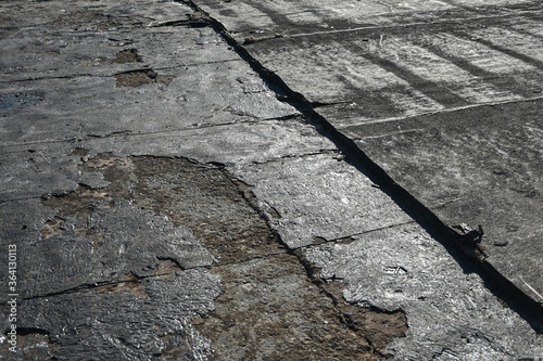 Bitumen flat roofing renovation, background texture of removed damaged insulation layer of roof