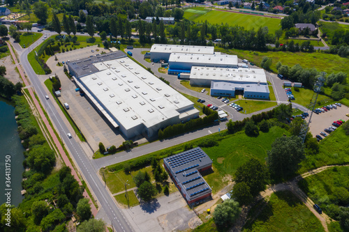 Aerial drone on trucks and logistic center. Warehouse aerial. Modern logistics center, white van and trailers standingon ramp.
