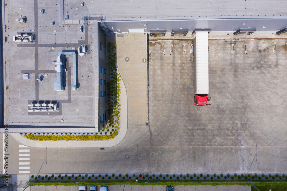 Aerial view of goods warehouse. Logistics center in industrial city zone from above. Aerial view of trucks loading at logistic center. View from drone. Aerial view of goods warehouse. Logistics center in industrial city zone from above. Aerial view of trucks loading at logistic center. View from drone.