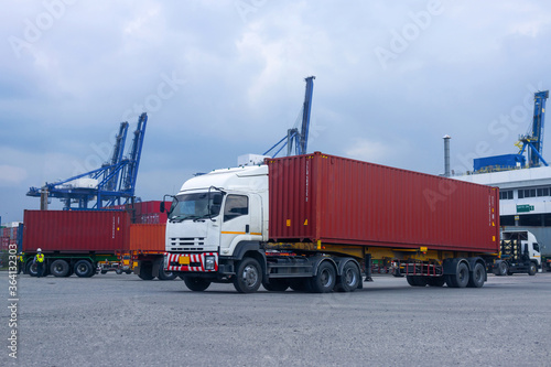 Container red truck in ship port Logistics.Transportation industry in port business concept.import,export logistic industrial Transporting Land transport freight warehouse storge