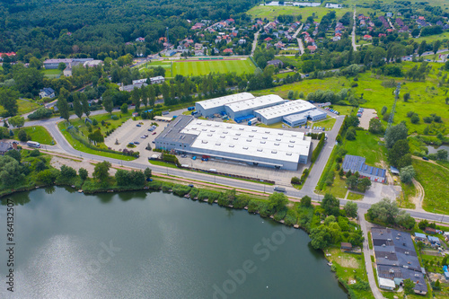 Aerial view of goods warehouse. Logistics center in industrial city zone from above. Aerial view of trucks loading at logistic center. View from drone