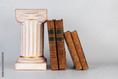 Ancient Greek column and old books. Isolated on white background. No labels, blank spine.