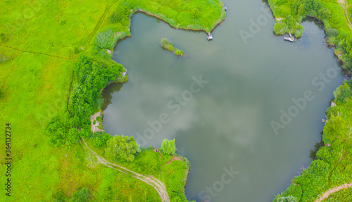 Tableau sur toile Aerial view of natural pond surrounded by pine trees