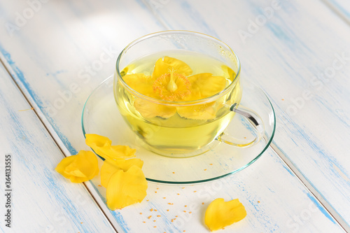 St. John's wort tea in a glass cup on the wood table. photo