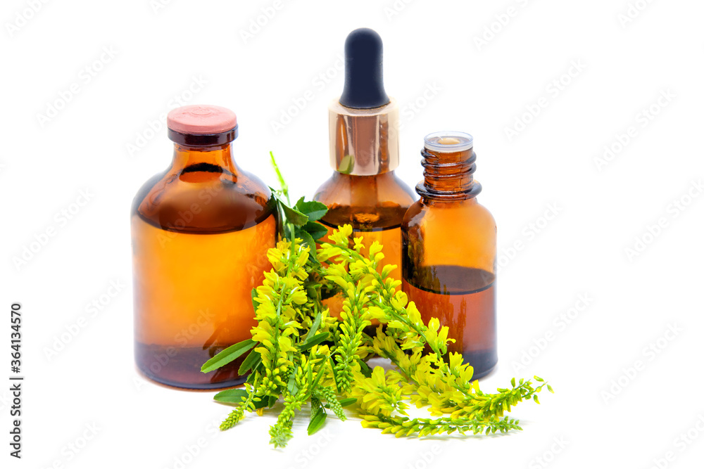 Melilotus officinalis flowers and pharmaceutical bottles on white