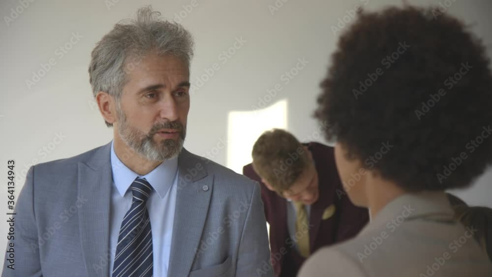Multiethnic business people standing in the modern office and discussing Multiethnic business people standing in the modern office and discussing