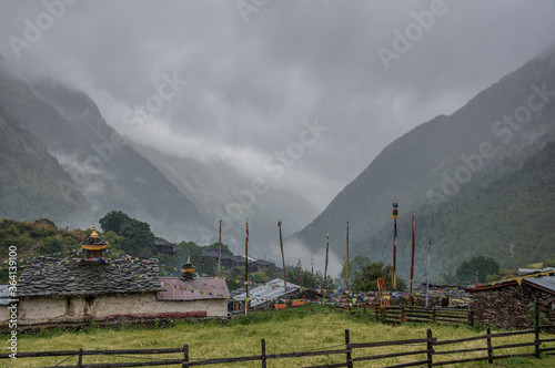 Lho Gaon village, known for its Gompa (monastery) and fine Stupa, on a wet, rainy, cloudy and gloomy afternoon, Manaslu Circuit trek, Gorkha district, Manaslu Himal, Nepal Himalayas, Nepal. photo