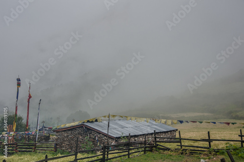 Lho Gaon village, known for its Gompa (monastery) and fine Stupa, on a wet, rainy, cloudy and gloomy afternoon, Manaslu Circuit trek, Gorkha district, Manaslu Himal, Nepal Himalayas, Nepal. photo