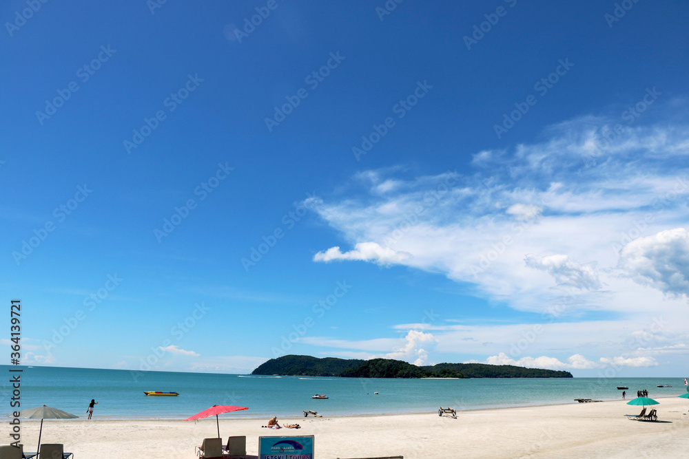 landscape view of pantai cenang beach at Langkawi Island with tourist attraction and background of blue sky and hills