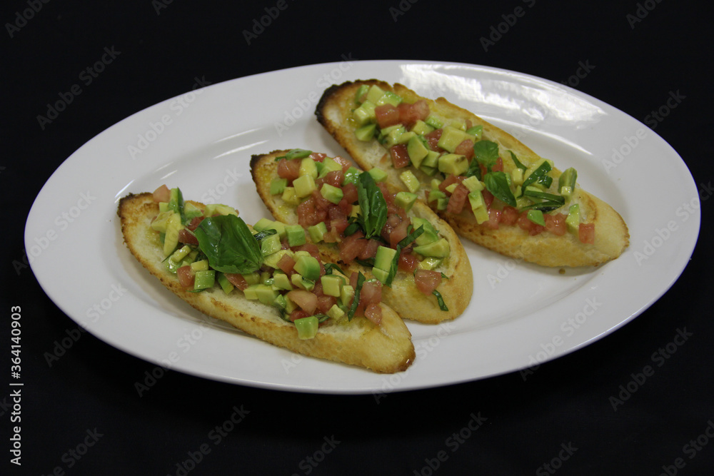 Sandwiches with red fish, basil and avocado on a white plate.Close-up Sandwiches with red fish, basil and avocado on a white plate.Close-up