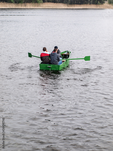 three men in a small green boat